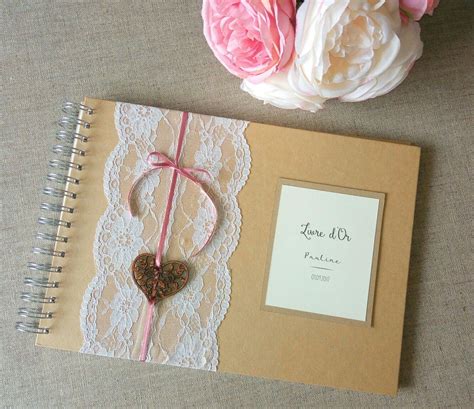 A Wedding Guest Book With A Heart On The Cover And Pink Flowers In The