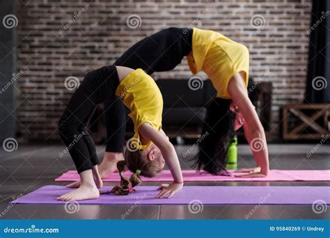 Two Flexible Girls Of Different Age Doing Upward Facing Bow Yoga Pose