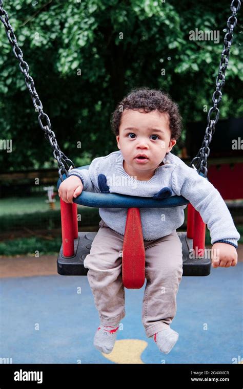 Cute Baby Boy Swinging On Swing In Playground At Park Stock Photo Alamy