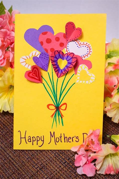 A Mothers Day Card With Paper Flowers And Hearts On It Next To Pink Carnations