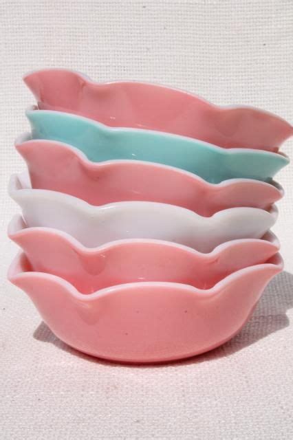 Three Pink And One Blue Bowls Sitting On Top Of Each Other In Front Of