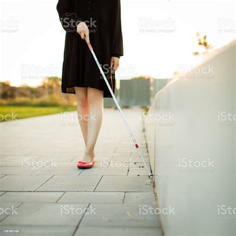 Blind Woman Walking On City Streets Using Her White Cane To Navigate