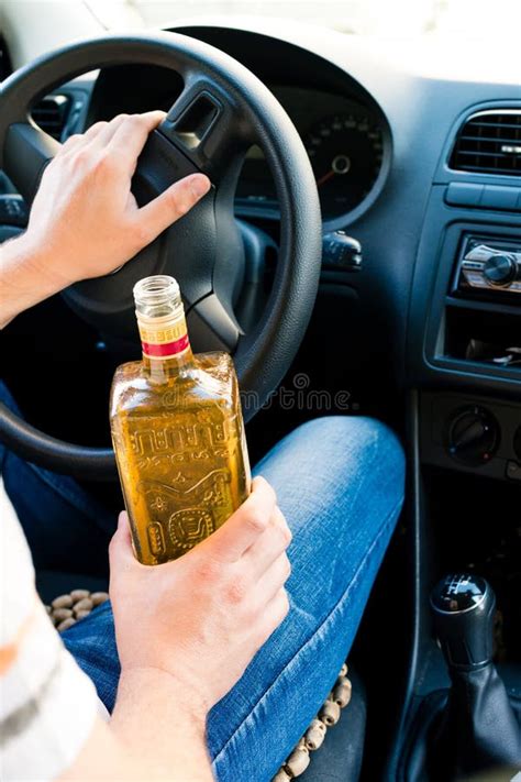 Drunk Man Sitting Behind The Wheel Of A Car And Drinking Alcoho Stock