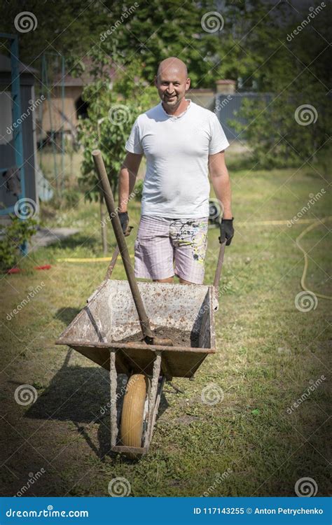 Man Pushing Wheelbarrow Young Man Pushing A Wheelbarrow On The Farm