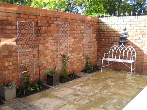 Patio with retaining wall garden design sloped backyard. Reclaimed brick walls in a small courtyard garden from a ...