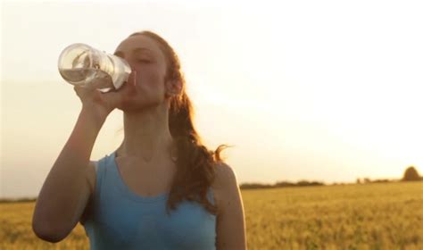 Stock Footage Athletic Female Model Drinking Water Summer Field Sunset