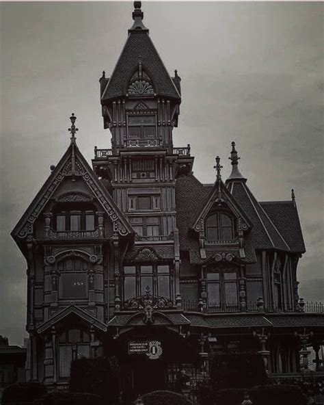 An Old House With Many Windows And A Clock Tower On The Top Of Its Roof