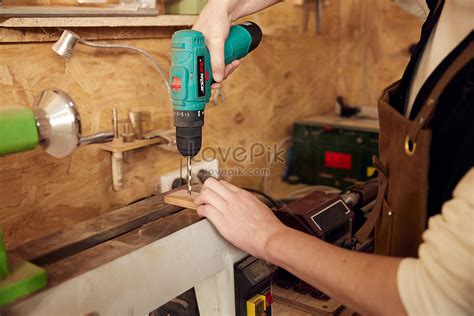 Close Up Of Male Craftsman Holding Electric Drill To Make Holes Picture