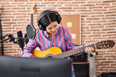 Young Chinese Woman Musician Playing Guitar At Music Studio Stock Image