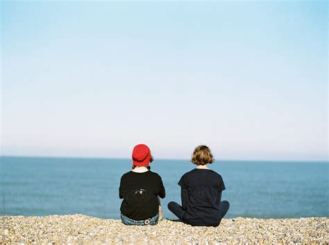 Two Friends Sitting On A Beach By Stocksy Contributor Kirstin Mckee