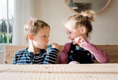 Brother And Sister Brushing Their Teeth At Home Before School Lizenzfreies Stockfoto