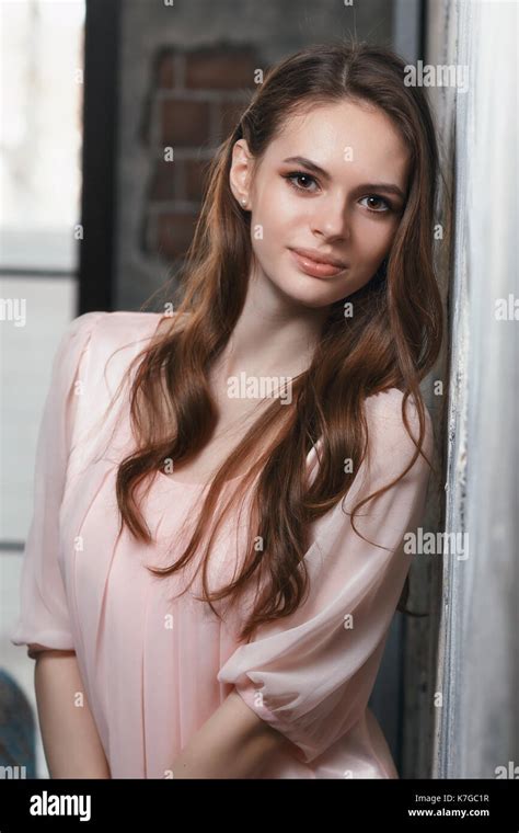 Young Beautiful Girl Posing Near The Wall Portrait Of A Model In A