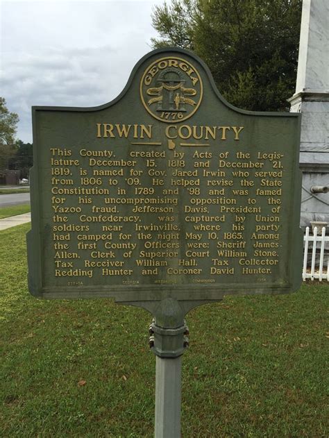 A Historical Marker In Front Of A White Picket Fence
