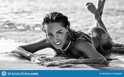 Smiling Woman Girl Is Lying On The Sand In The Incoming Waves Of The
