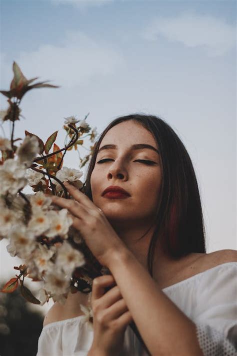 Woman In White Shirt Holding White Flower · Free Stock Photo