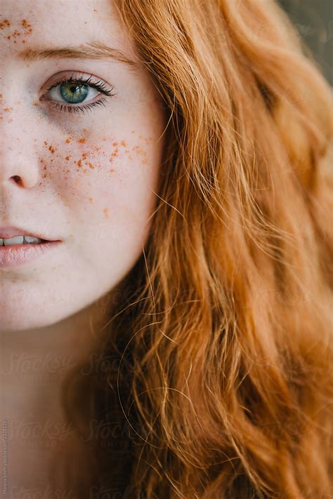 close up of a scottish ginger haired girl with freckles and green eyes by stocksy contributor