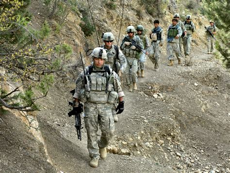Us Army Soldiers And Afghan Border Policemen Walk Along A Mountain