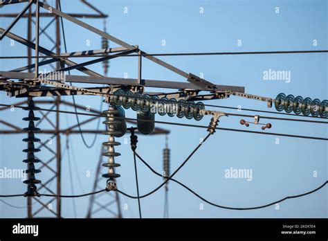Insulators Of High Voltage Overhead Power Lines Are Under Blue Sky On A
