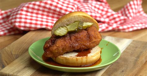 Nashville hot chicken sandwich on plate over brown background. You'll Dream of These Delicious Nashville Hot Chicken Sandwiches...They're So Good!