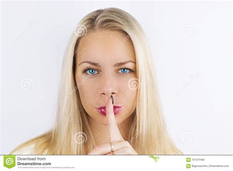 shh women`s secrets beautiful blond woman with blue eyes holding her finger to her pink lips