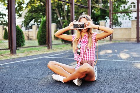 Stylish Young Woman Using A Camera To Take Photo Outdoors Stock Photo
