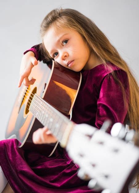 Free Photo Thoughtful Little Girl Playing Acoustic Guitar