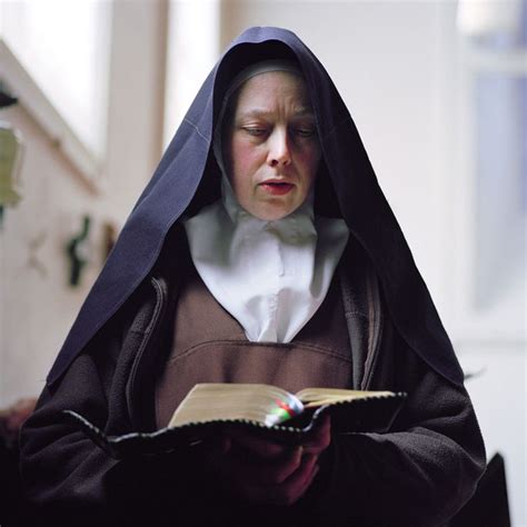 a nun reading a book with her eyes closed