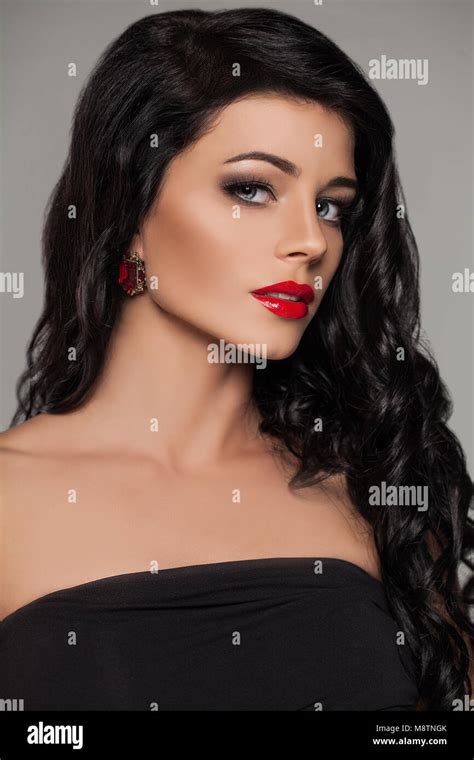 Perfect Brunette Model Face Young Woman With Red Lips Makeup Long Curly Hair And Ruby Earrings