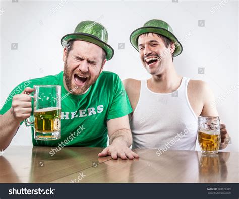 Two Irish Friends Getting Drunk On Saint Patricks Day In Bar Together Laughing Cracking Up Over