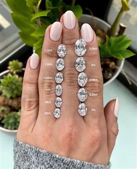 A Womans Hand With Three Different Sized Diamonds On It