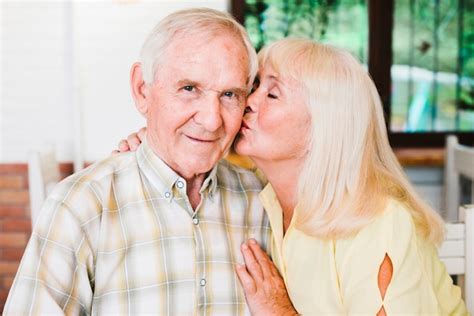 Free Photo Delighted Senior Couple Hugging Sitting In Cafe And Kissing
