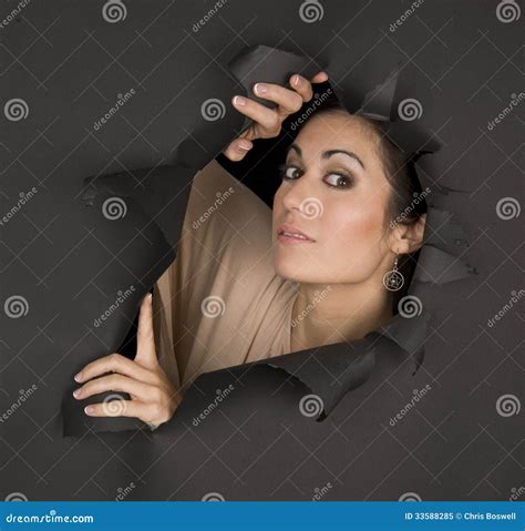 Beautiful Brunette Woman Looks Sideways Through Torn Hole Stock Image