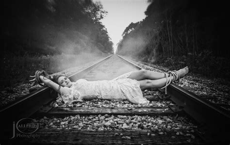 Damsel In Distress Tied To The Railroad Tracks Waiting On A Hero