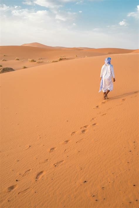 Man Walking On Desert During Daytime Photo Free Nature Image On Unsplash