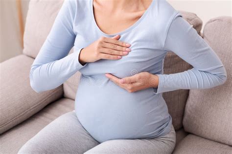 Unerkennbare Schwangere Dame Massiert Brust Auf Couch Zu Hause