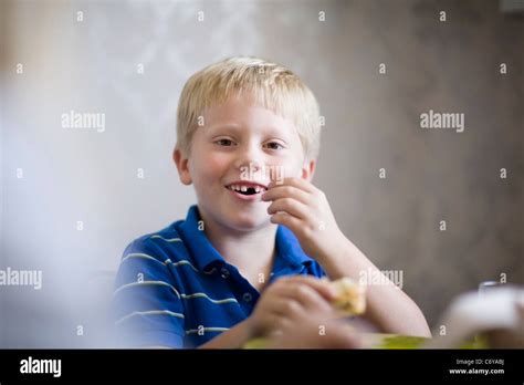Boy Eating At Dinner Table Stock Photo Alamy