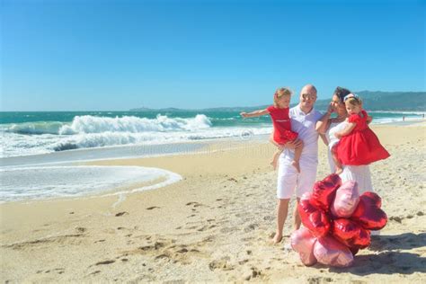 Gelukkige Familie Die Met Twee Jonge Geitjes Op Het Strand Stellen Stock Afbeelding Image Of
