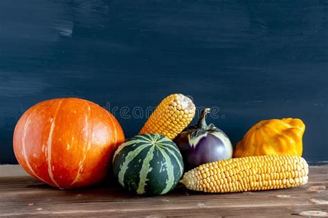 Autumn Pumpkins And Other Fruits And Vegetables On A Wooden