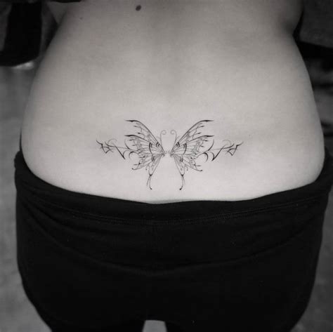 Fine Line Butterfly Tattoo Located On The Lower Back