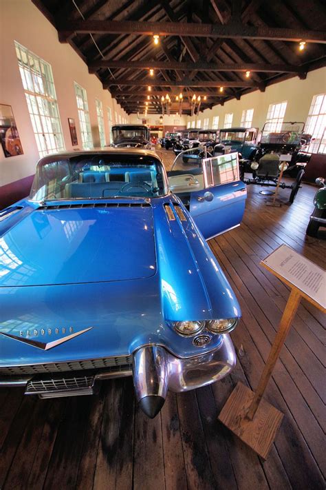 an old blue car is on display in a building with wooden floors and
