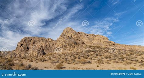 Panoramic Of Brown Mojave Desert Rock Formations Under A Blue Sky With