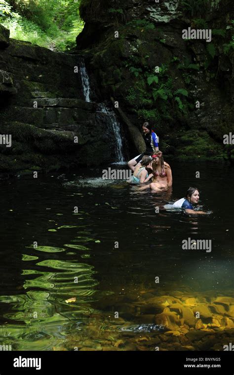 A Group Of Young Girls Enjoy A Swim At A Waterfall Freshwater Pool