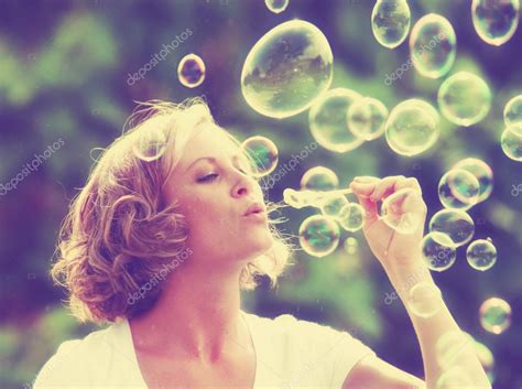 Beautiful Woman Blowing Bubbles — Stock Photo © Graphicphoto 53627779