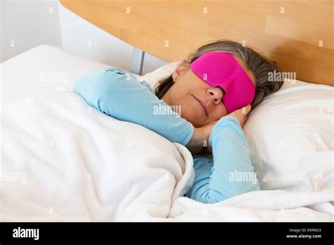 Older Woman Lying In Bed And Sleeping Peacefully With A Sleep Mask On