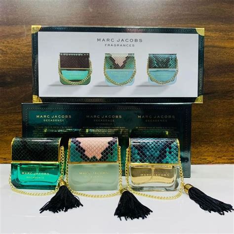 Three Bottles Of Marc Jacobs Perfumes In Front Of A Box With The Contents