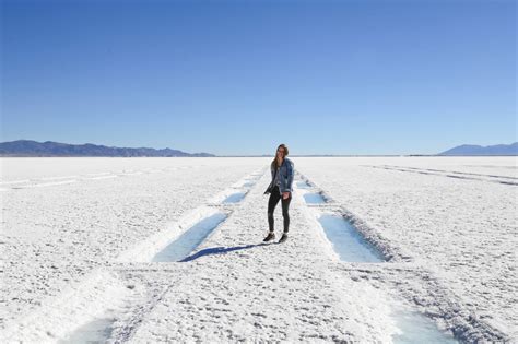 A Woman Standing In The Middle Of A Salt Flat