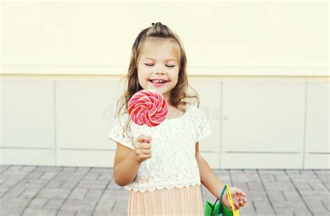 Happy Smiling Child With Sweet Caramel Lollipop Having Fun In City