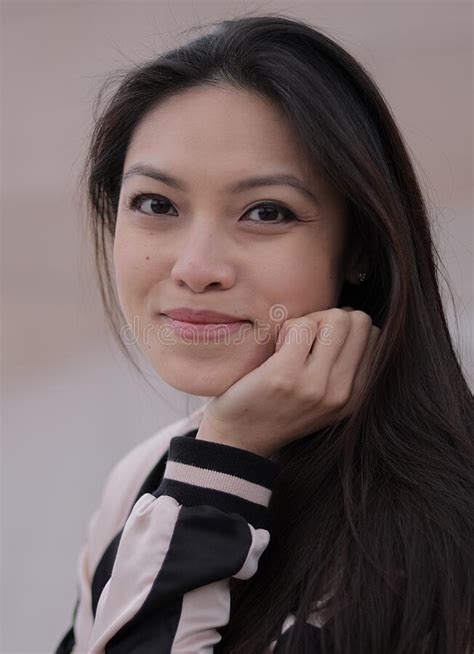 Young Asian Woman Poses For The Camera In An Urban Area Stock Image