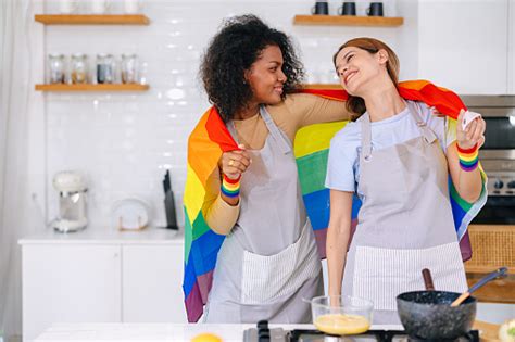 Pasangan Lgbt Wanita Bahagia Merayakan Bulan Kebanggaan Bersama Dengan Bendera Pelangi Di Dapur
