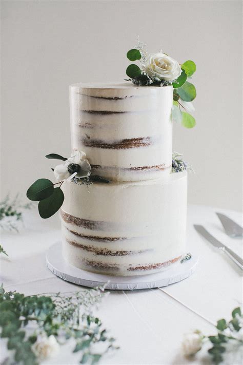 Minimal Semi Naked Cake With White Icing And Flowers